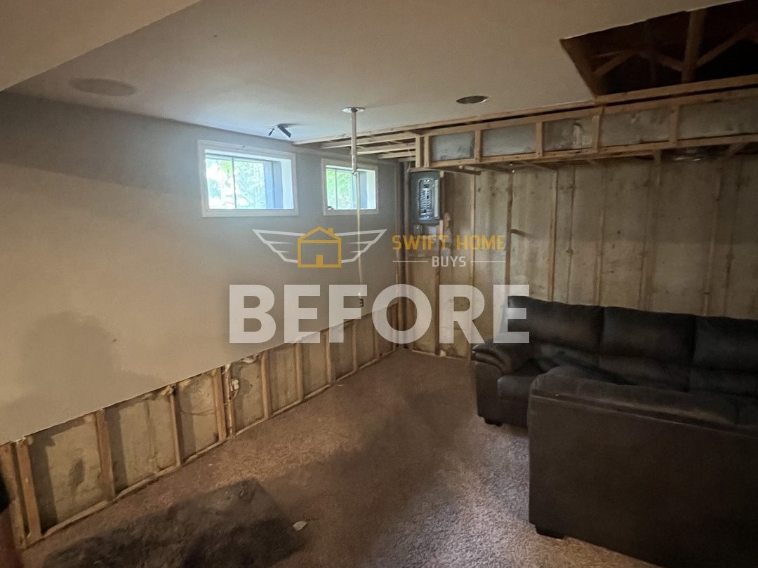 Manchester basement before: half-finished walls with open framing and old carpet