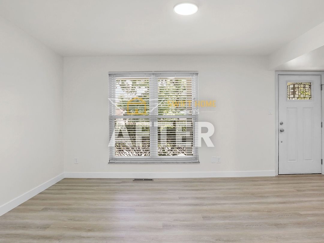 Manchester living room after renovation: white walls and new plank flooring
