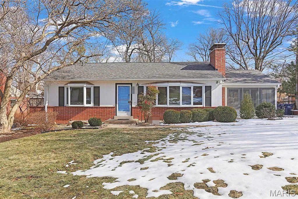 Brick ranch with a blue front door and a screened porch in Kirkwood, MO, after Swift Home Buys bought and updated it