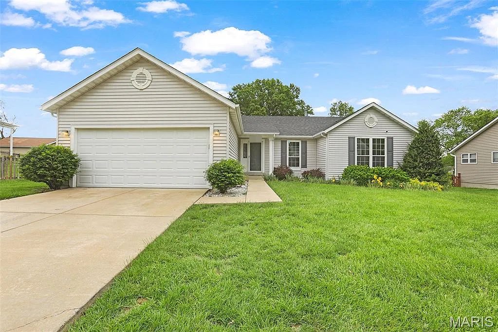 Ranch house with a two-car garage in O'Fallon, MO, after Swift Home Buys bought it, cleaned it out and made repairs