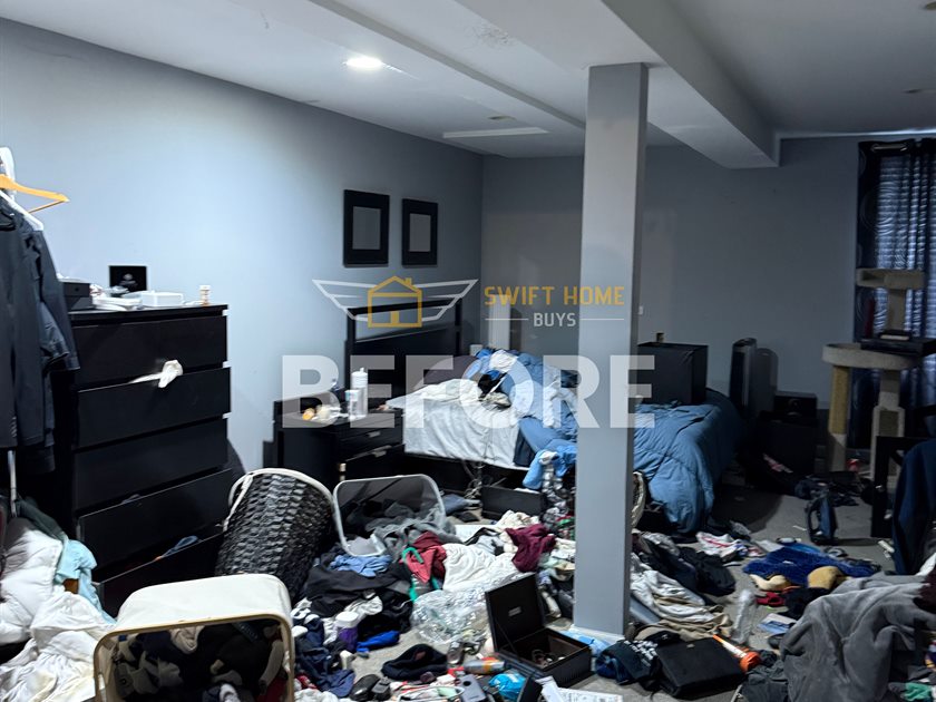 St. Charles basement before: clothes, bags and furniture piled across the floor