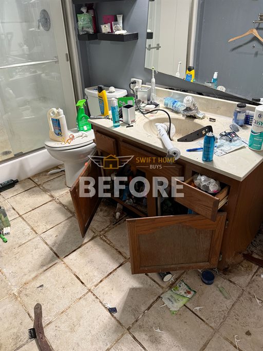 St. Charles bathroom before: worn vanity and stained tile floor