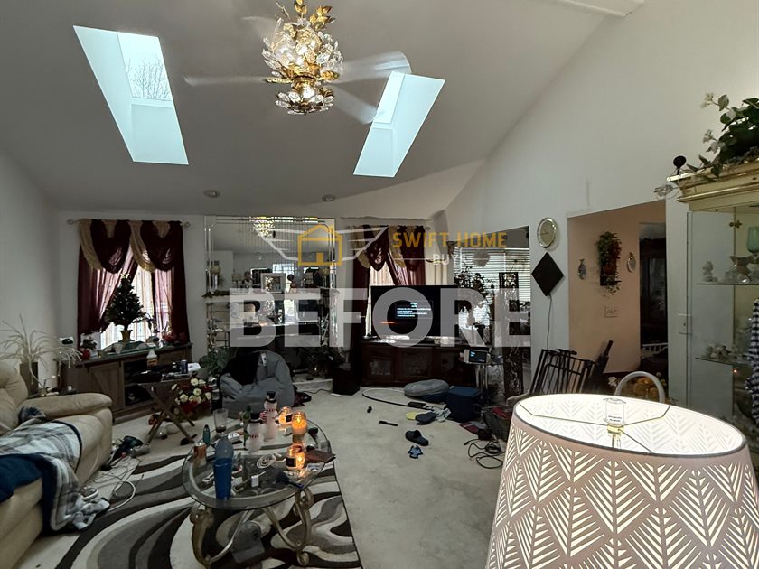 St. Charles living room before: crowded furniture and worn carpet under the vaulted ceiling