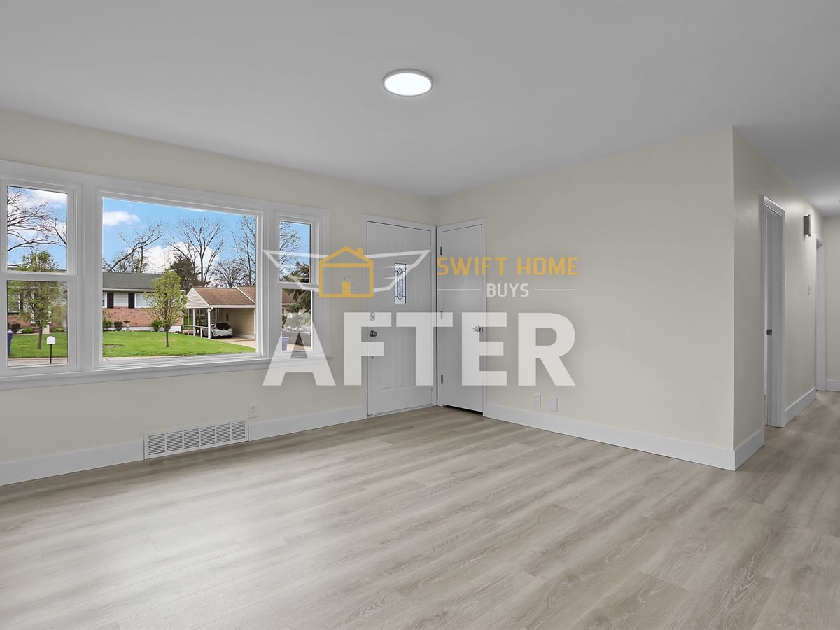 St. Louis County living room after renovation: new plank flooring, fresh paint and new lighting