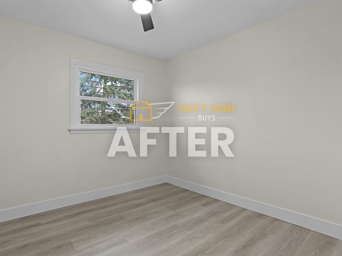 The same St. Louis County bedroom after renovation: new flooring, fresh paint and a ceiling fan