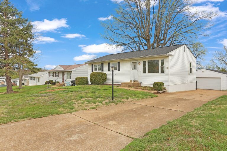A white ranch-style house with a detached garage on a quiet St. Louis County street
