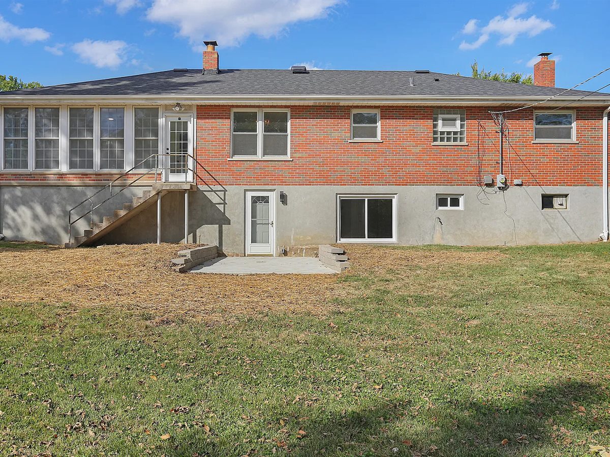 Back of the Sunset Hills ranch after, with a new roof, a cleaned-up yard and a new patio by the lower-level door