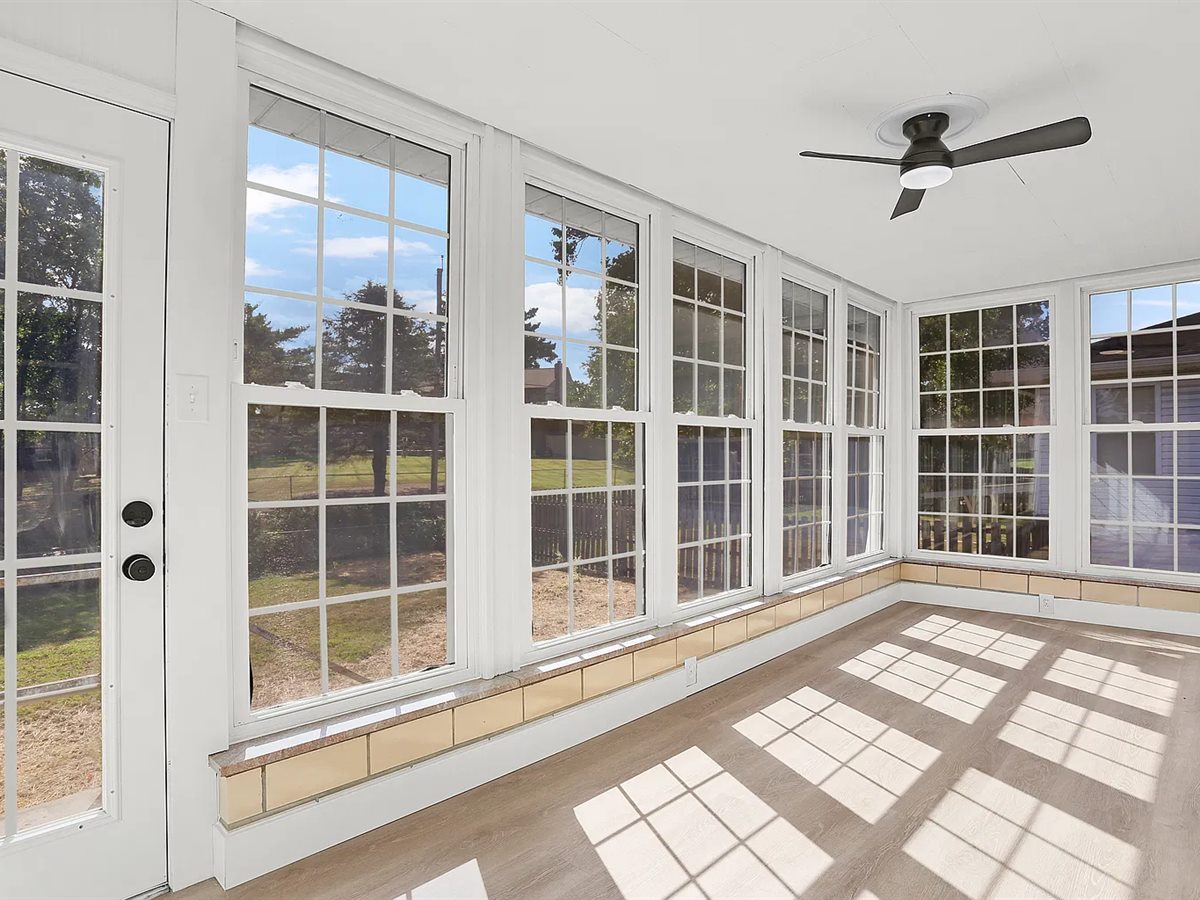 The same Sunset Hills sunroom after: new plank flooring, white walls and a new ceiling fan