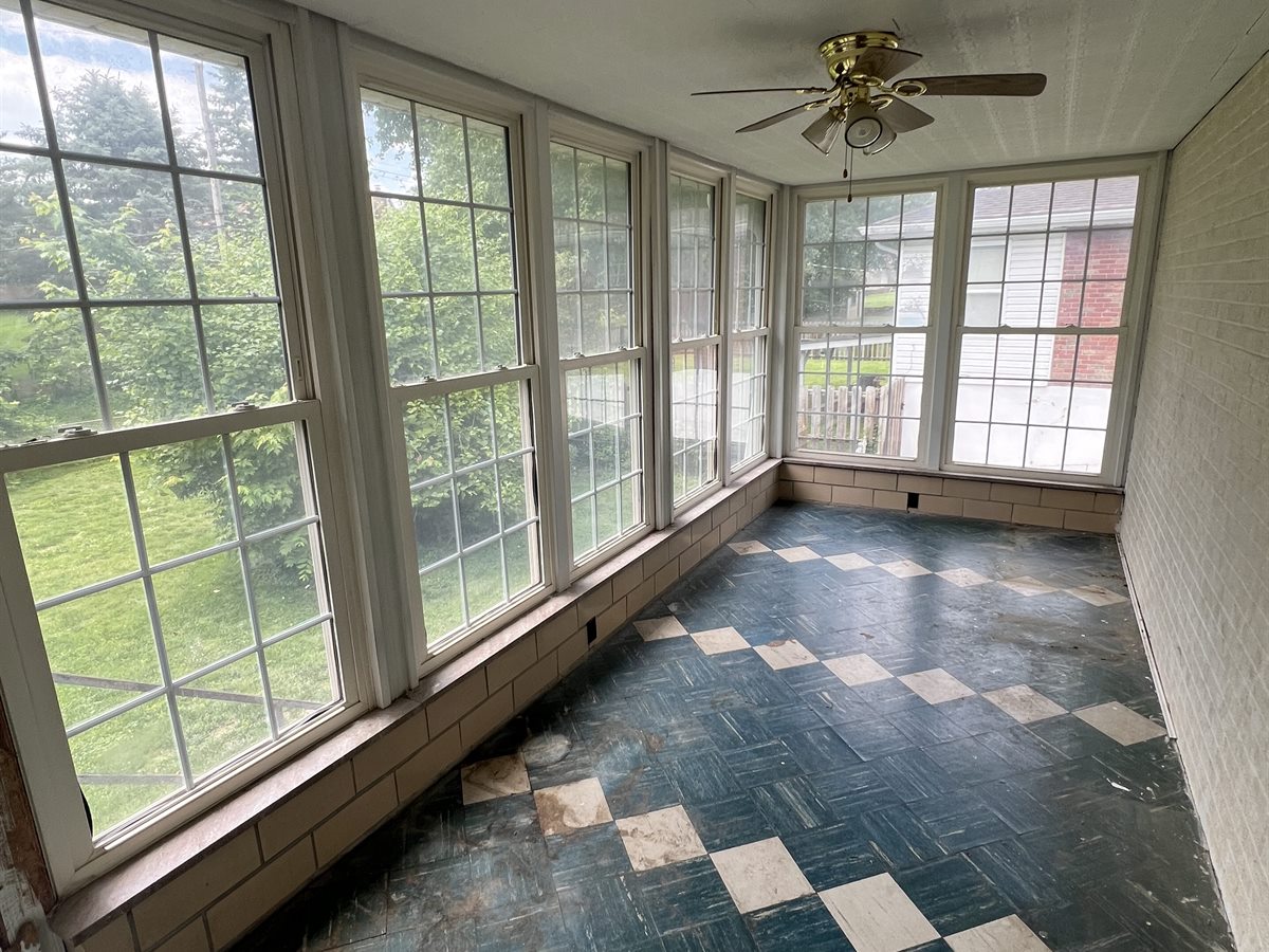 Sunset Hills sunroom before: worn blue and white tile floor and a dated brass ceiling fan