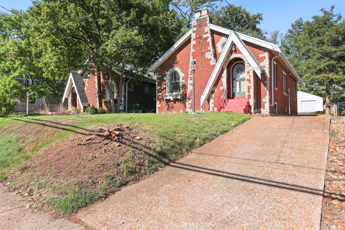Brick bungalow with an arched front door and stone trim in Webster Groves, MO, after Swift Home Buys bought it