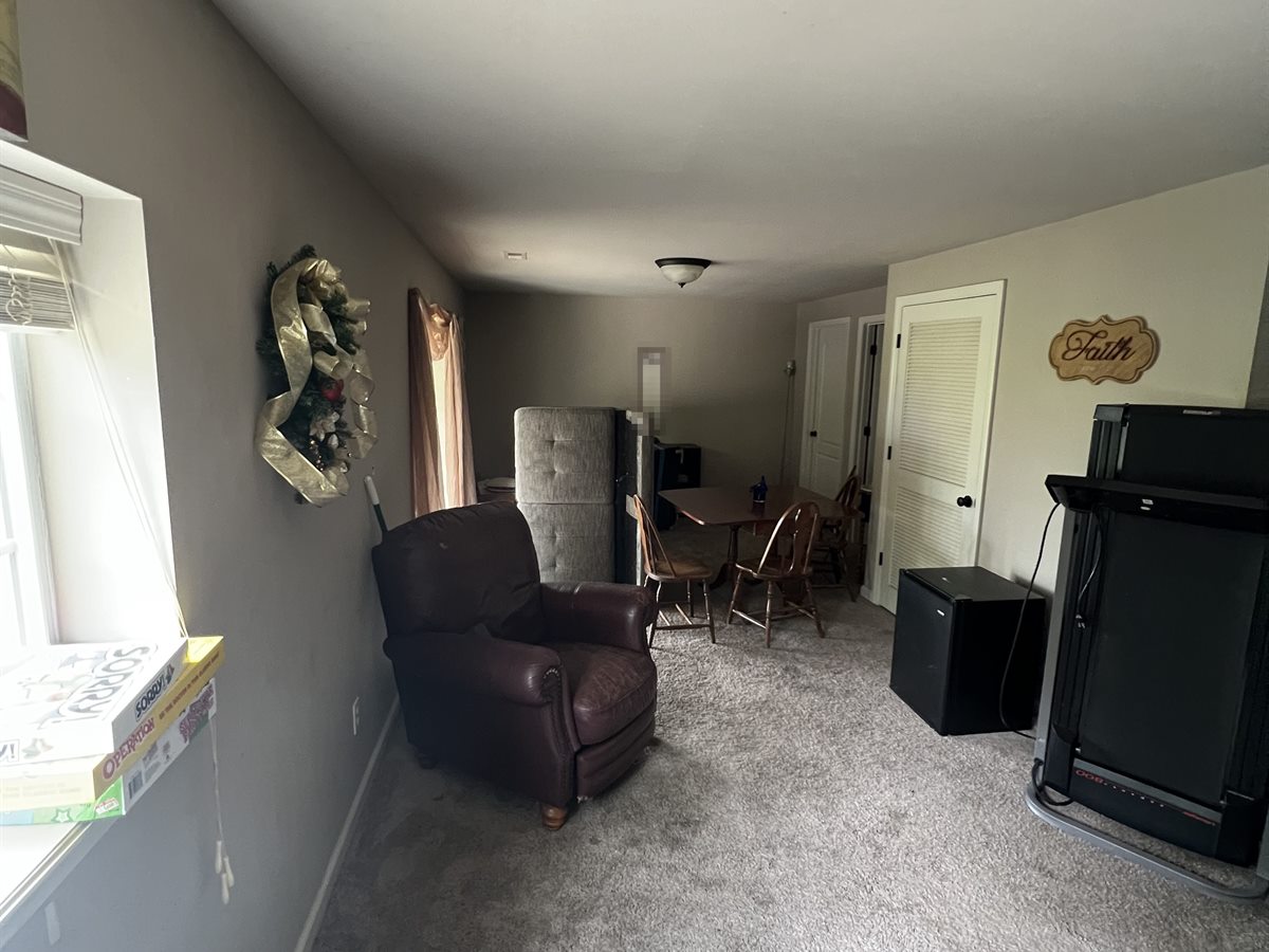 Wentzville lower level before: worn, stained carpet, gray walls and the seller's furniture